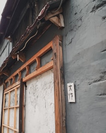 A rustic wooden sign with carved lettering hanging on a cozy living room wall.