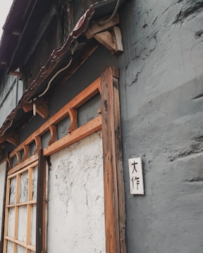 A rustic wooden sign with carved lettering hanging on a cozy living room wall.