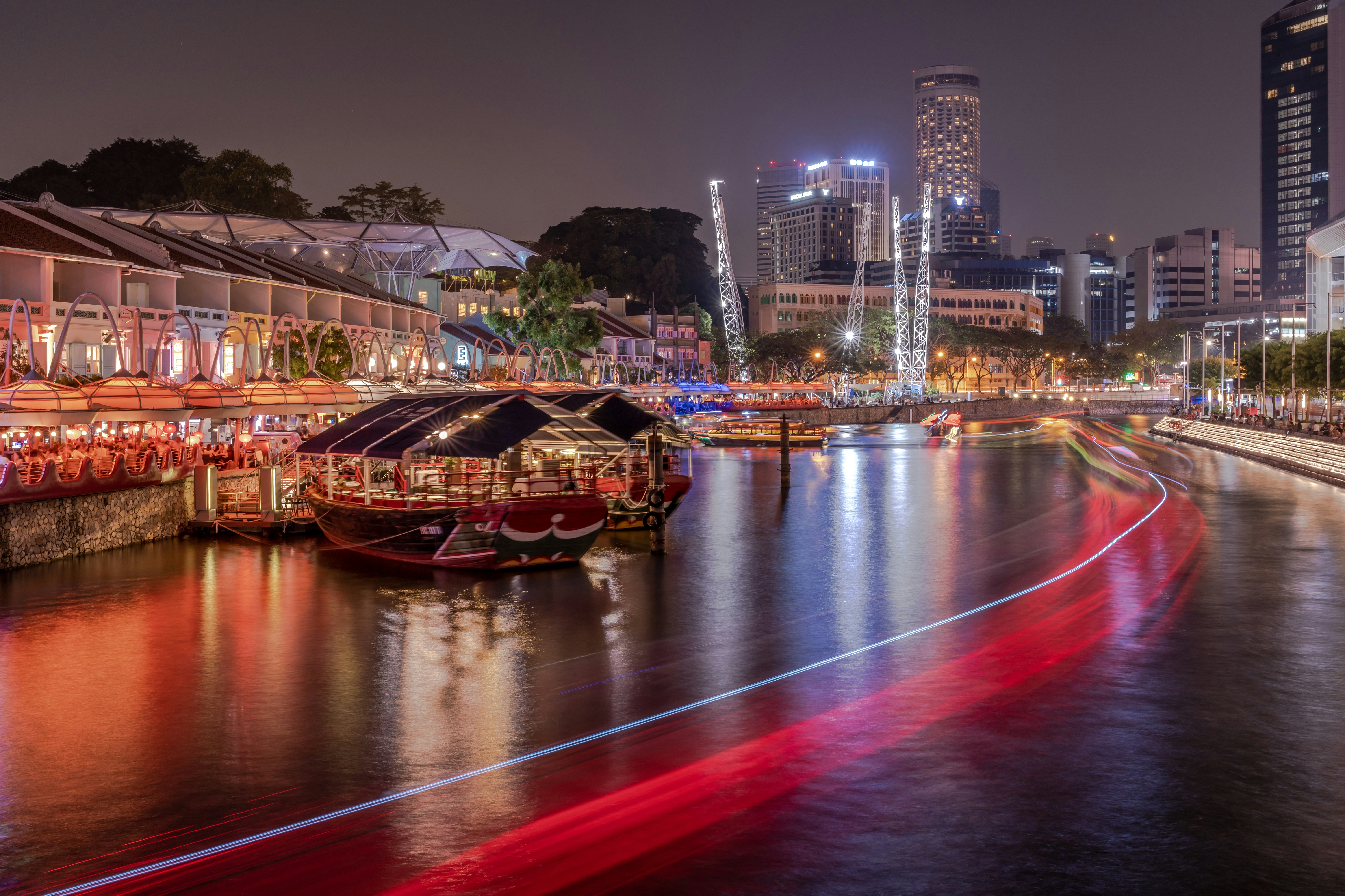 rotes und braunes Boot auf dem Fluss während der Nacht