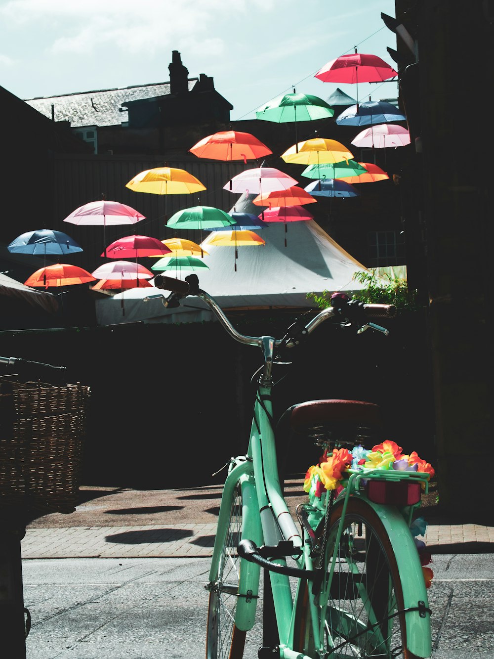 green bicycle with umbrella near umbrella during daytime