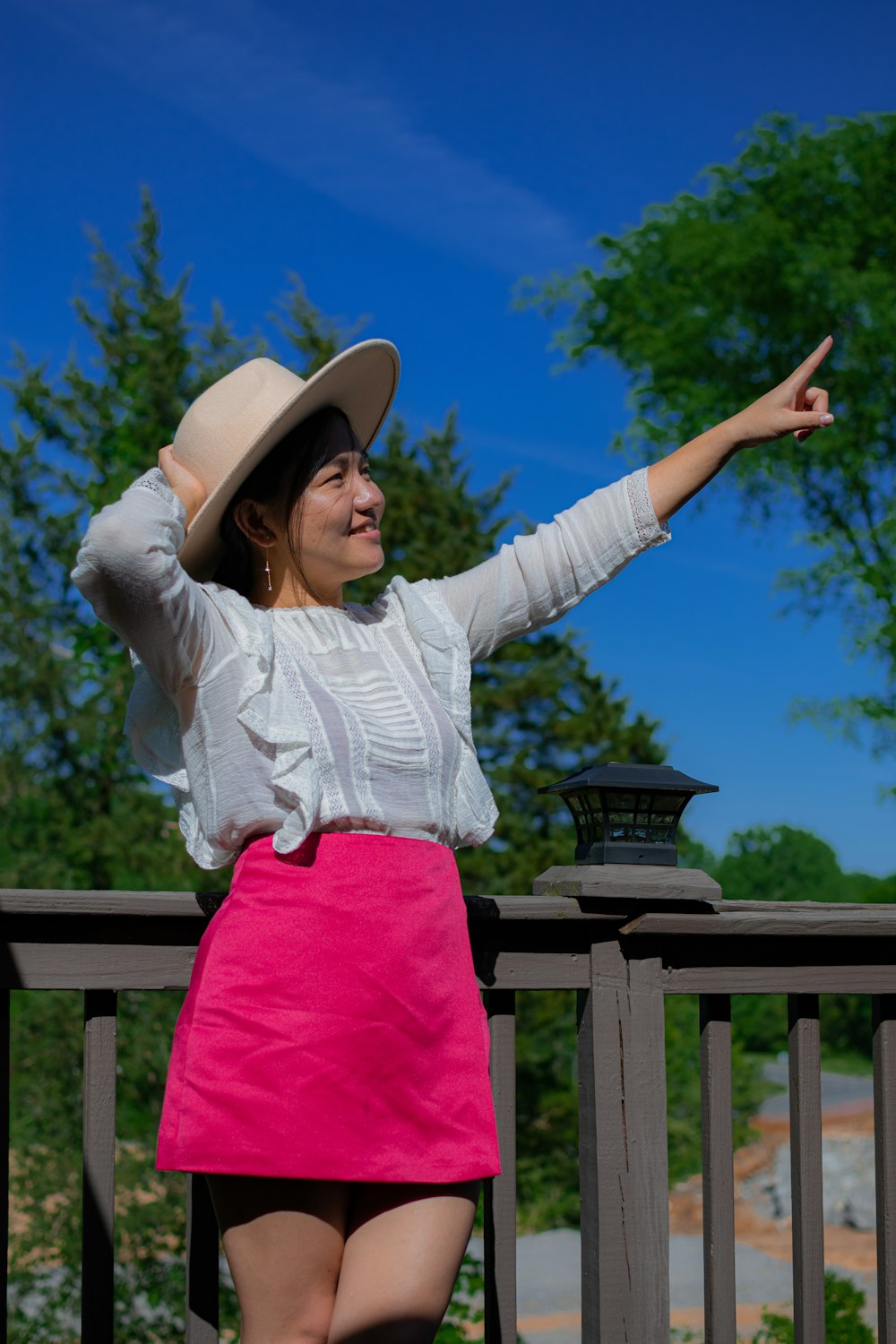 woman in white long sleeve shirt and pink pants wearing brown hat