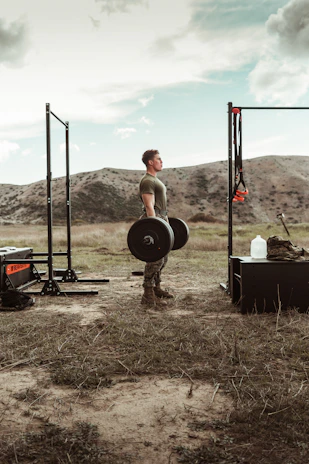 A smiling trainer guiding a client through a strength workout outdoors at sunrise on the prairie.