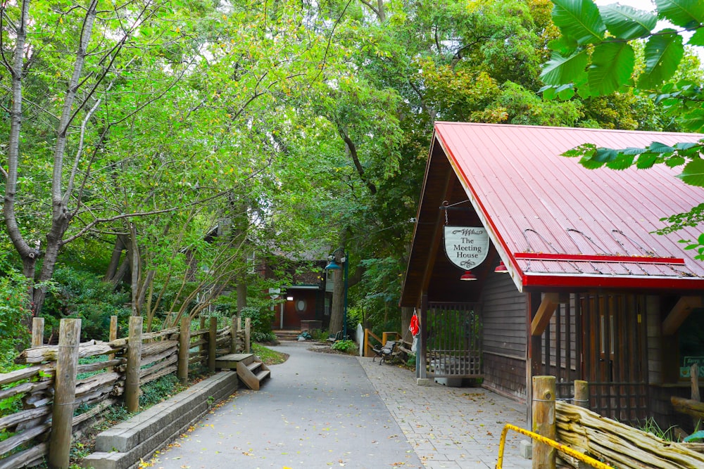 red and white wooden house near green trees during daytime