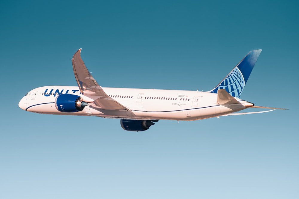 avião de passageiros branco e azul em voo