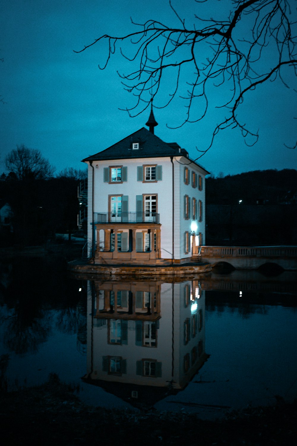 white and brown concrete house near body of water during night time