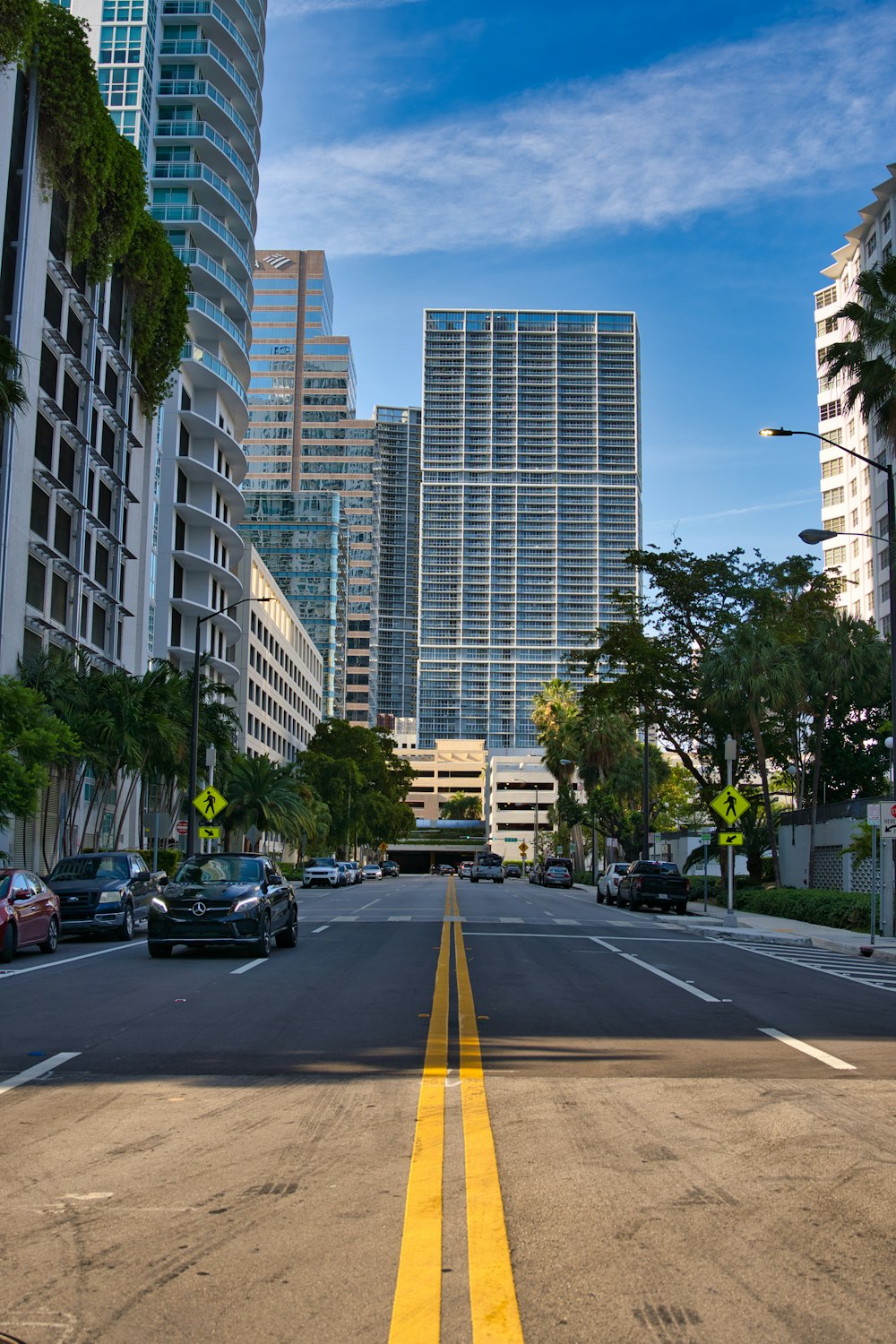 cars on road near high rise buildings during daytime