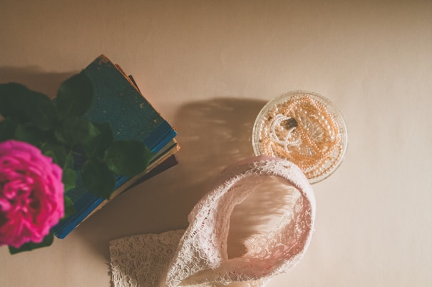 A flat lay of romance e-books with shimmering silver and gold accents, surrounded by delicate white flowers.