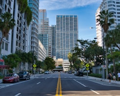 cars on road near miami high rise buildings during daytime