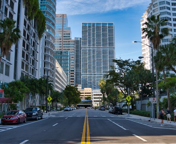 cars on road near miami high rise buildings during daytime