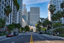cars on road near miami high rise buildings during daytime