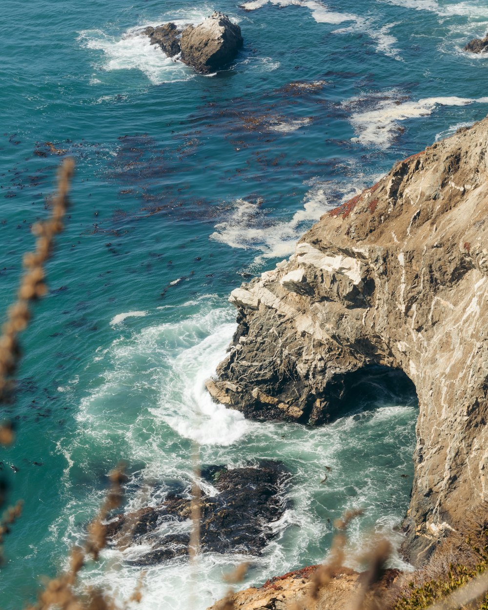 brown rock formation on body of water during daytime