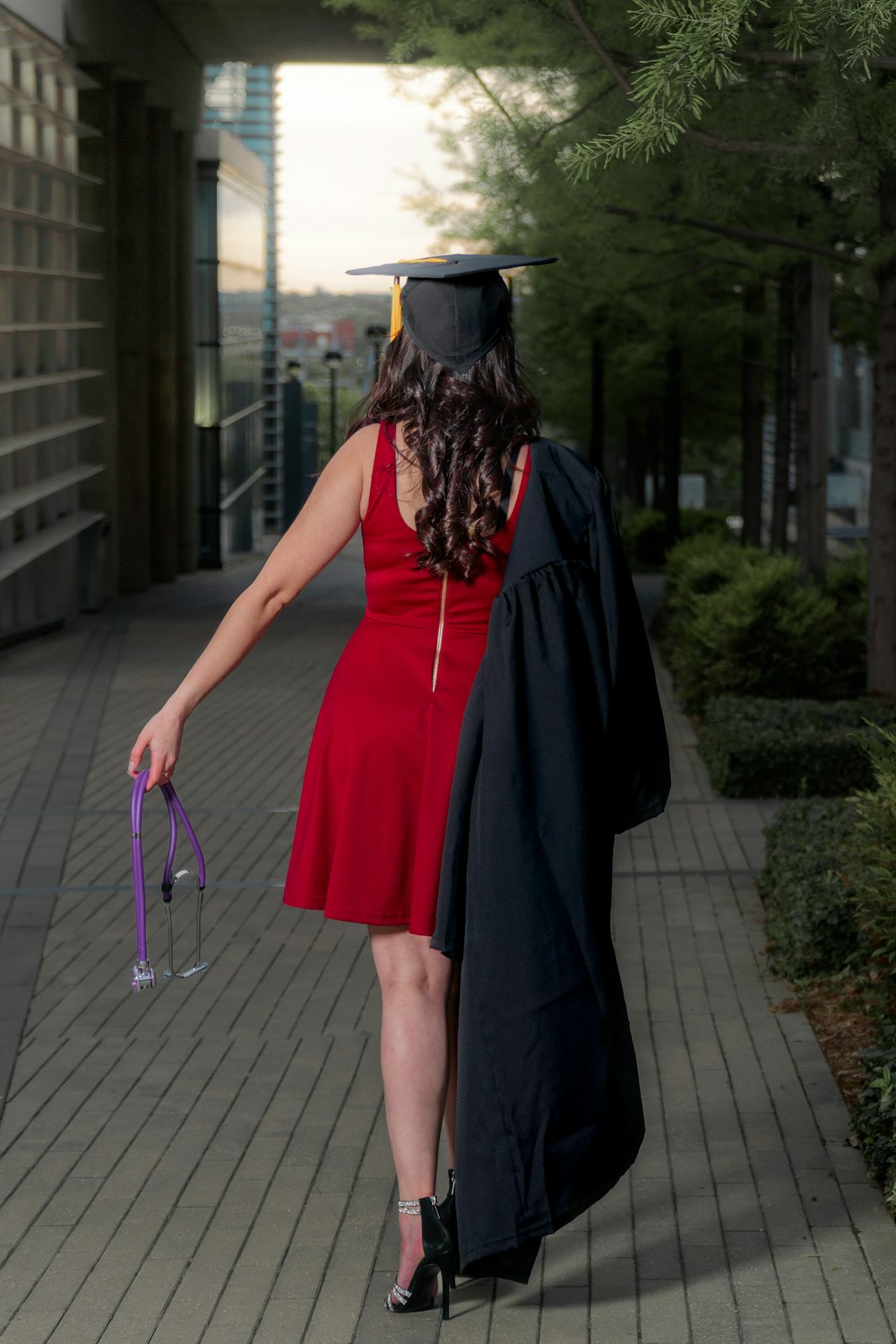 donna in abito senza maniche rosso che indossa cappello accademico nero