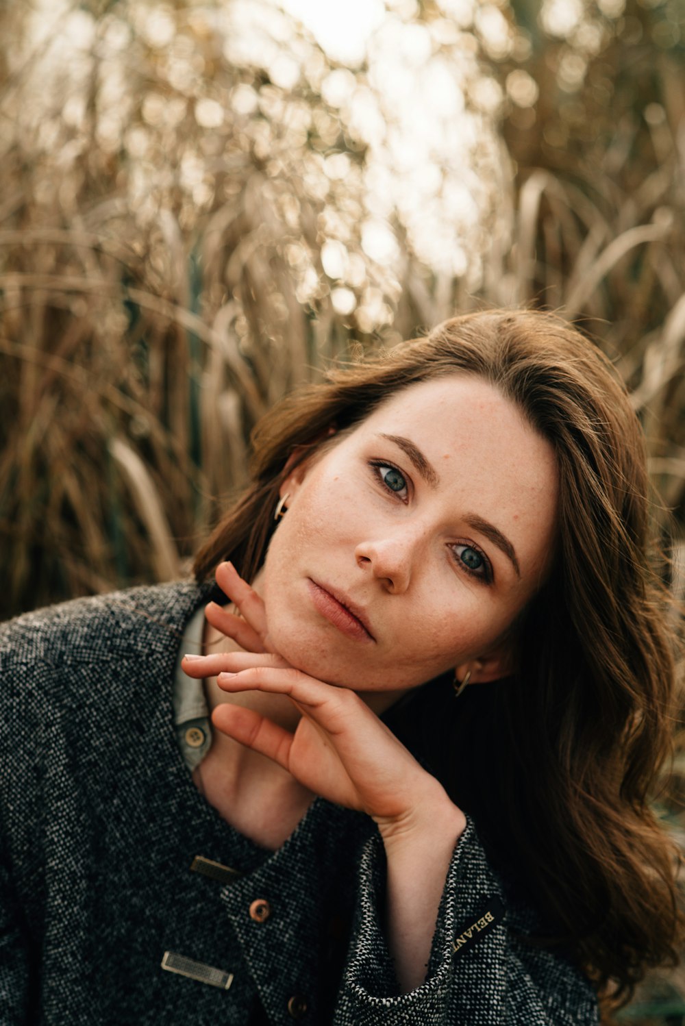 woman in gray sweater holding her face