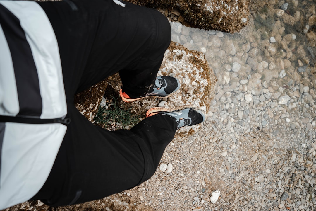 person in black pants and black and white sneakers