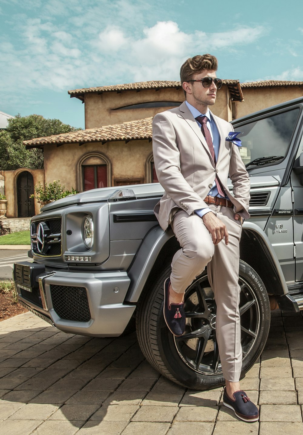 man in white suit sitting on gray car