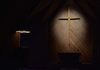 brown wooden cross on brown wooden wall