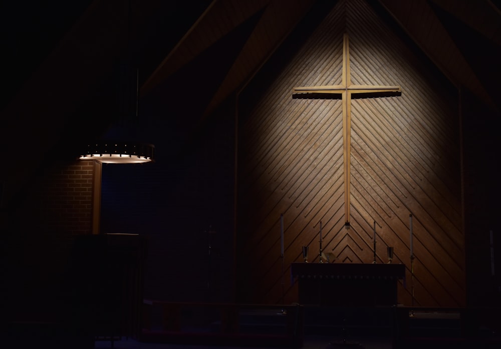 brown wooden cross on brown wooden wall