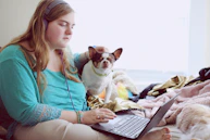 girl in blue jacket holding white and brown short coated puppy