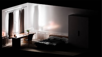 A minimalist bedroom with a modern aesthetic. It features a bed with dark bedding, a wooden desk with a plant and lamp, a chair, a wardrobe, and a large window with curtains. The room is softly lit, creating a serene atmosphere.
