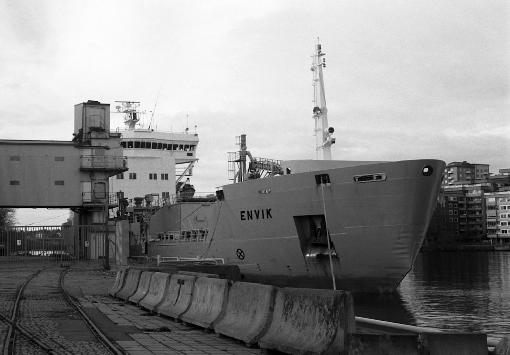 grayscale photo of ship on dock