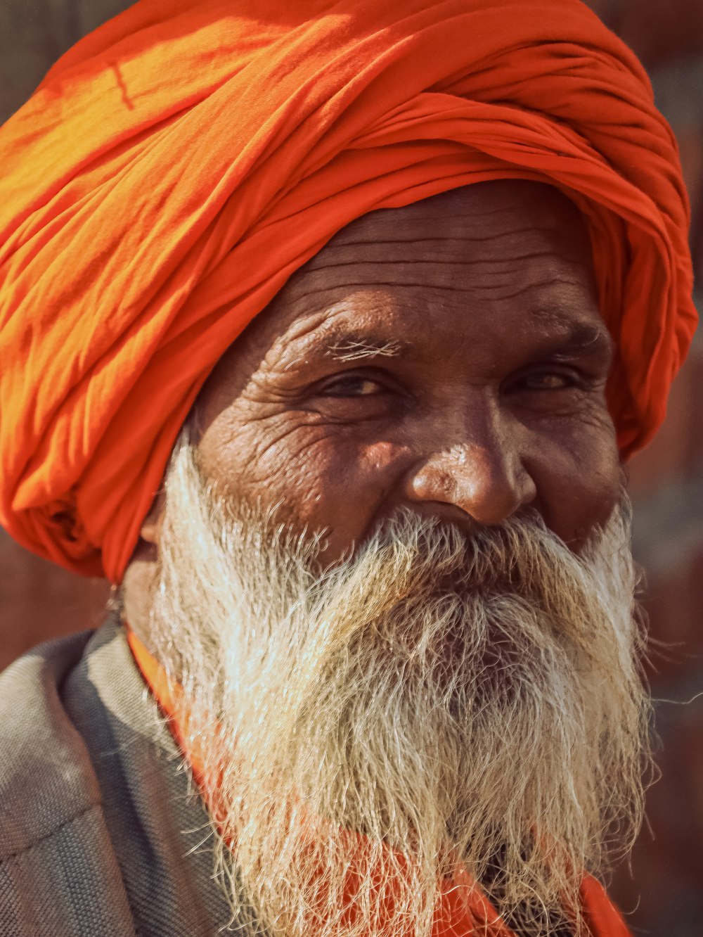 man in orange turban and gray coat