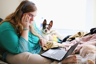 woman in teal long sleeve shirt holding black laptop computer
