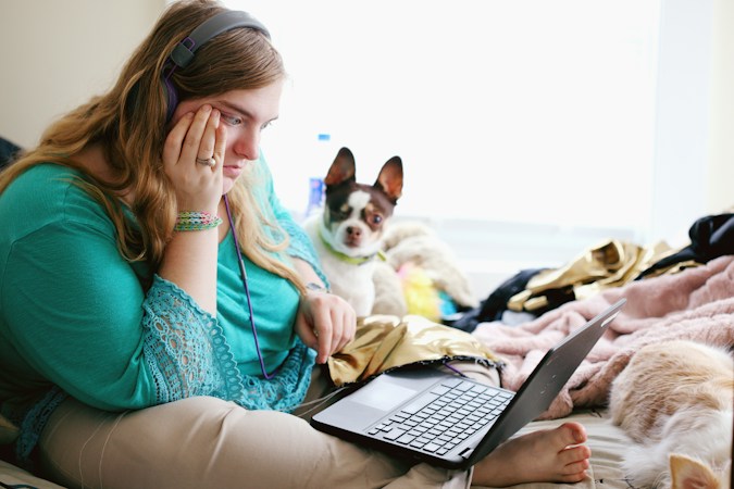 A parent holding a laptop while researching special education resources and school options in Las Vegas