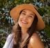 smiling woman wearing brown hat and white tank top