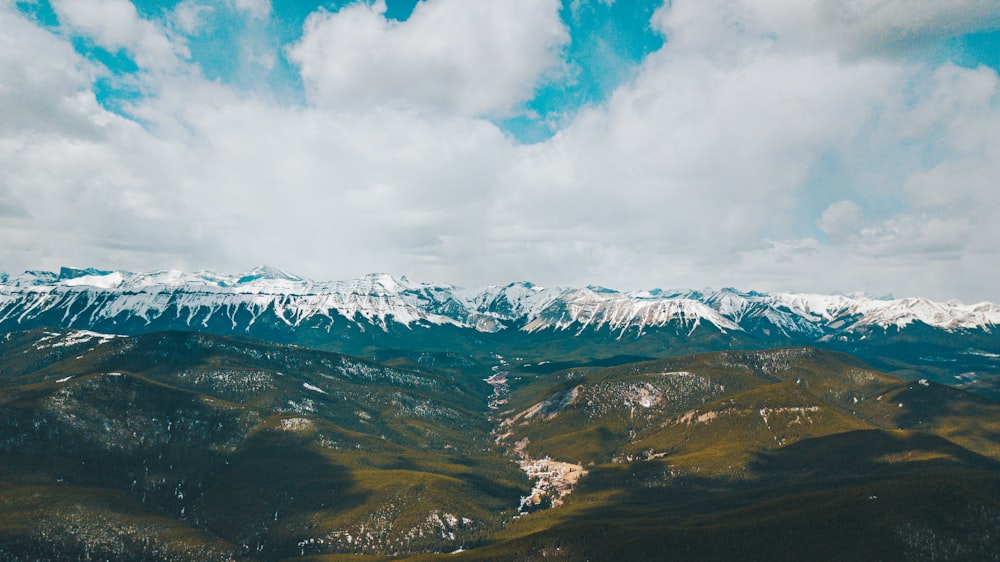 snow covered mountains under cloudy sky during daytime