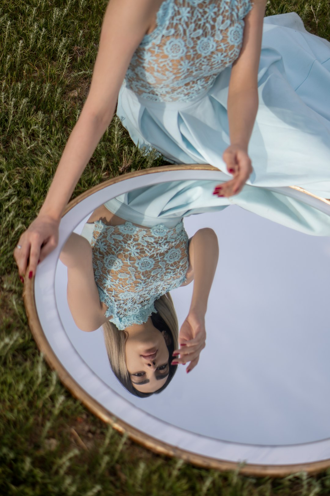 girl in white and blue floral dress lying on green grass field