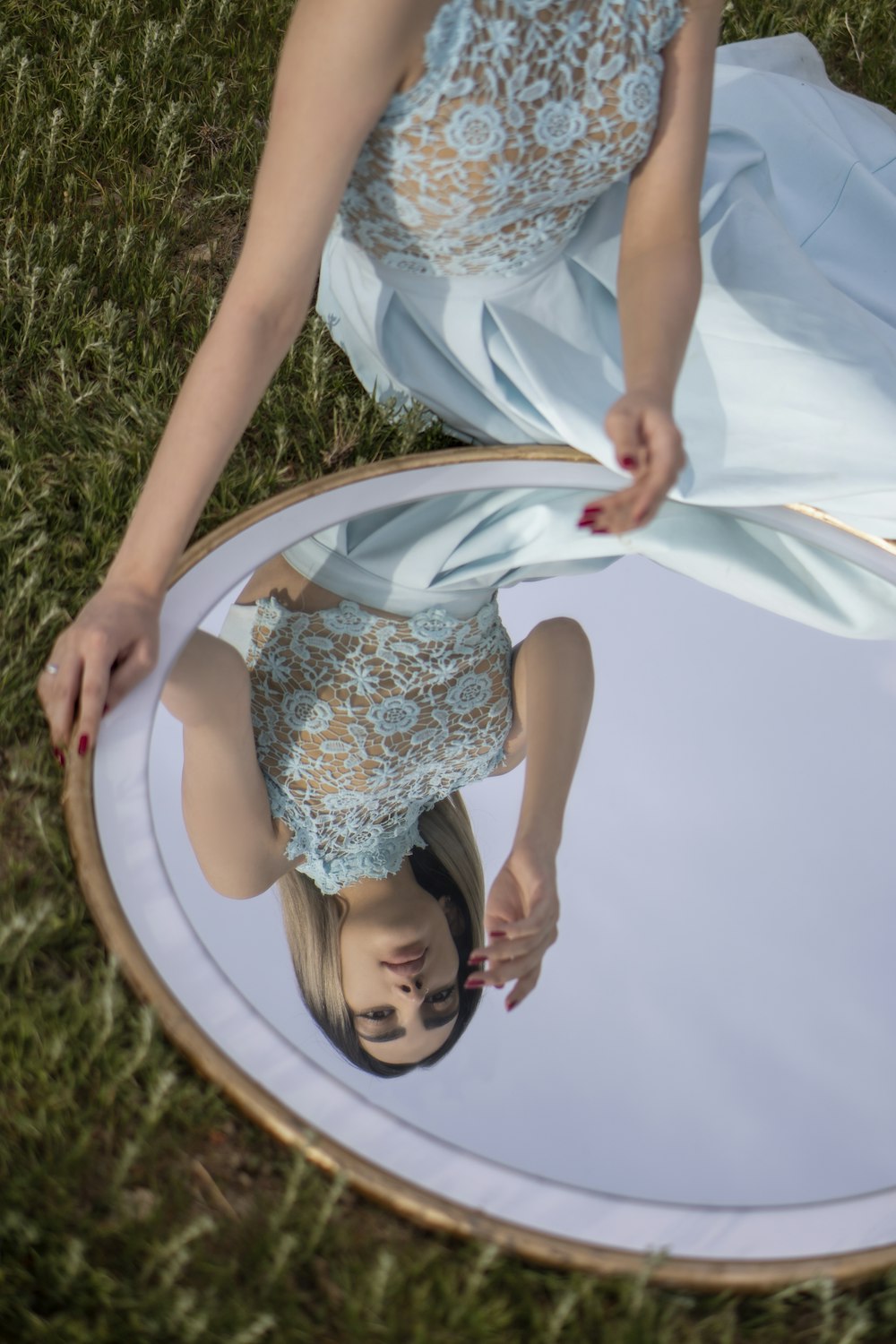 girl in white and blue floral dress lying on green grass field