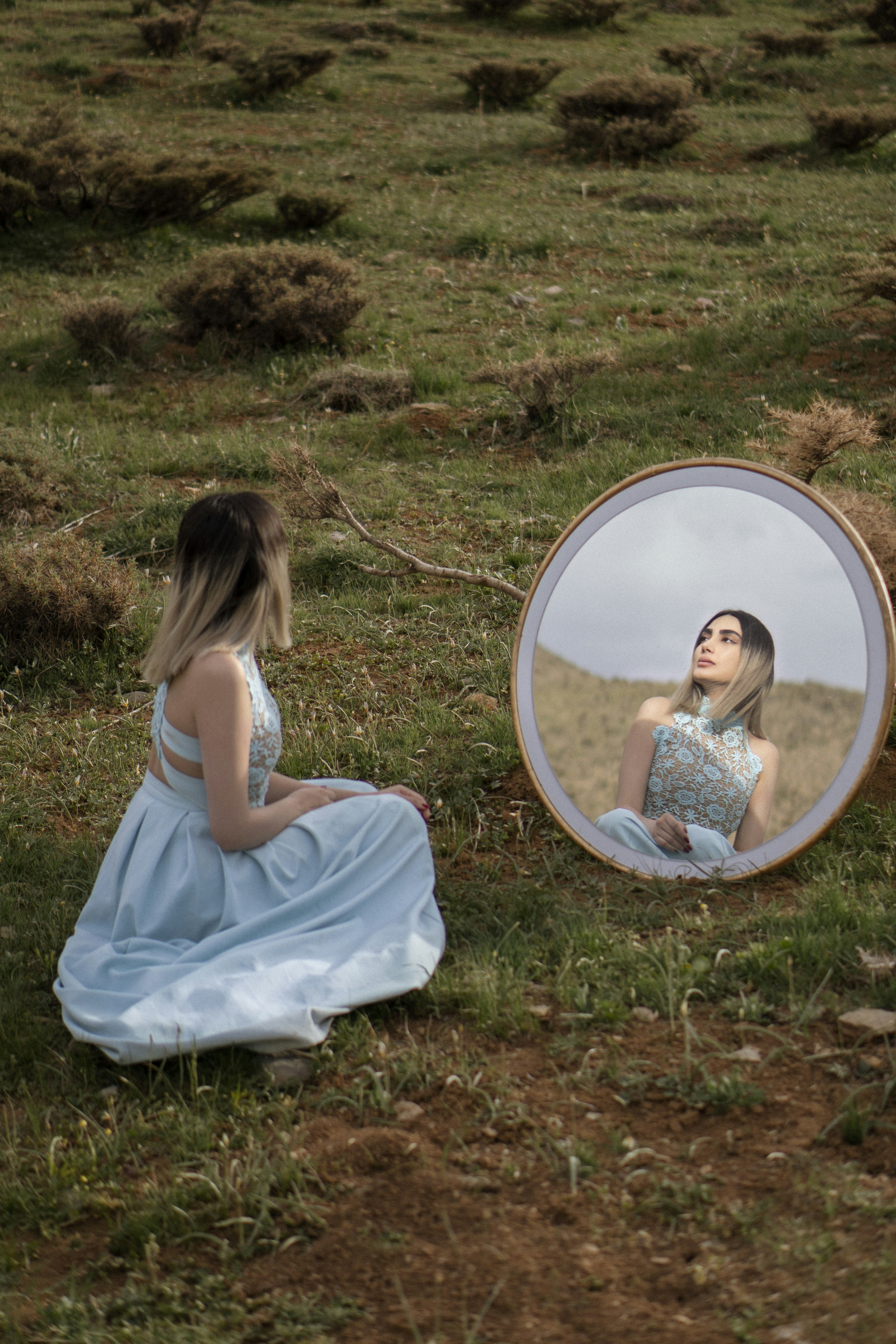 girl in white dress sitting on green grass field