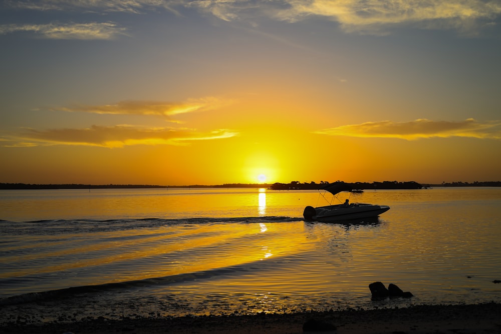 silhouette of person on boat on sea during sunset