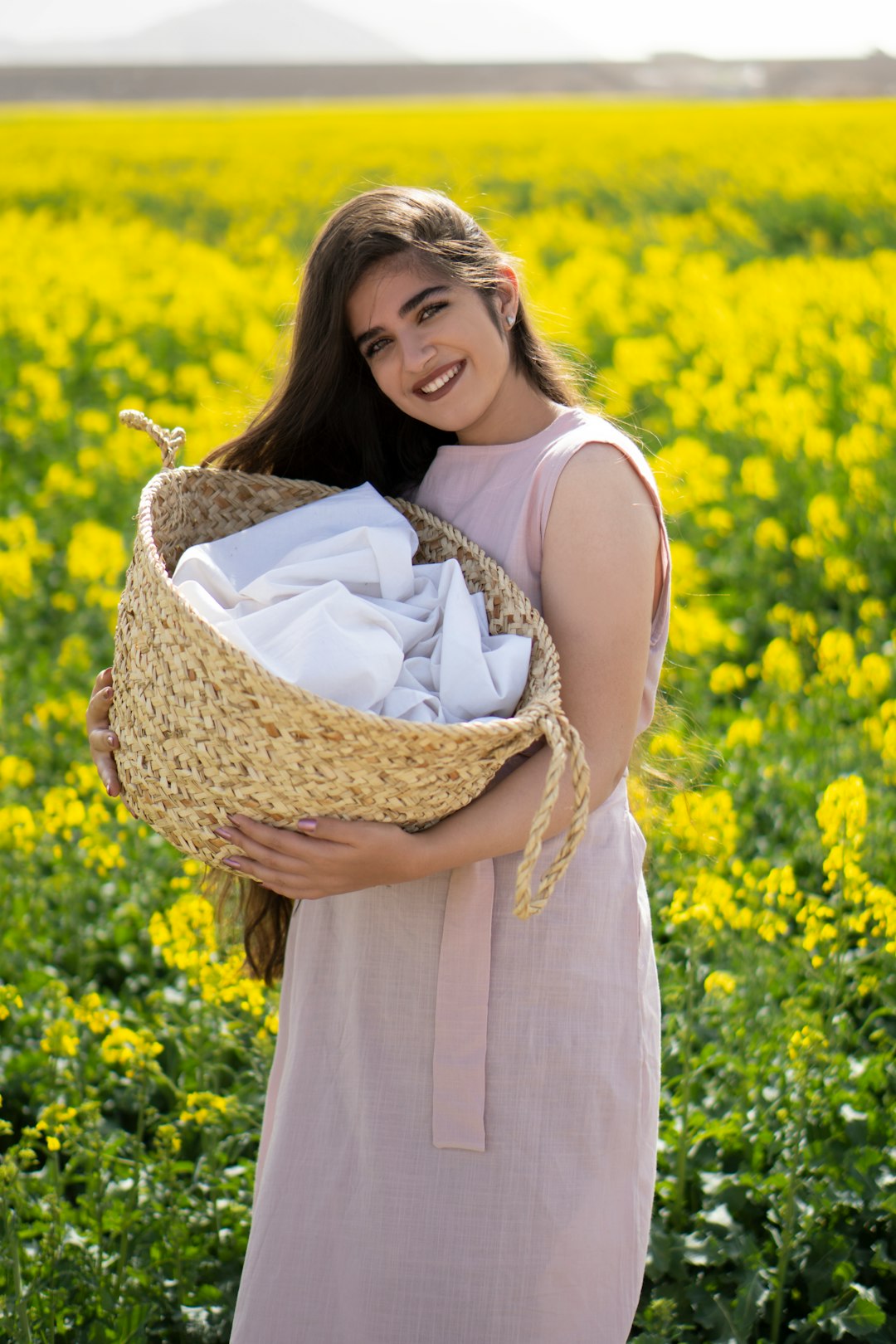 woman in white sleeveless dress holding brown woven basket