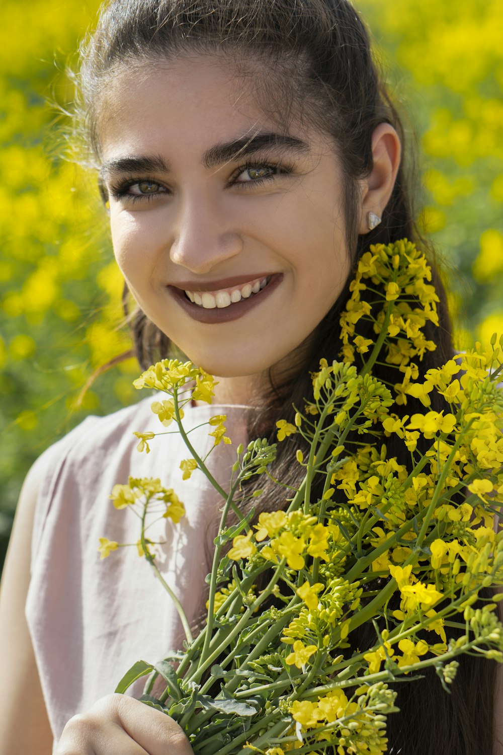 mulher sorridente na camisa branca com flores amarelas na cabeça