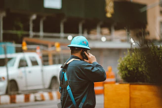 man in blue jacket wearing orange helmet