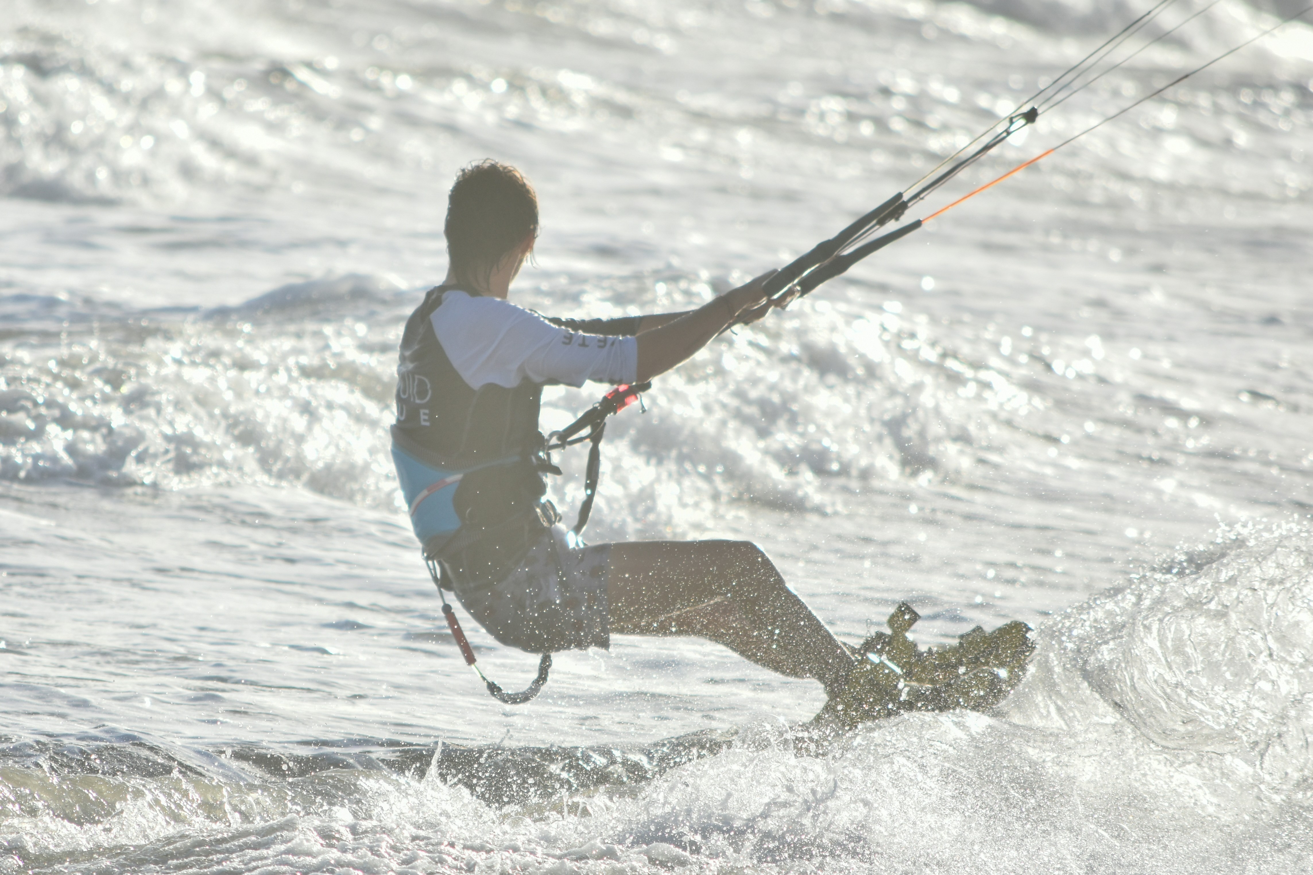 man in blue and yellow shirt and brown pants surfing on sea waves during daytime