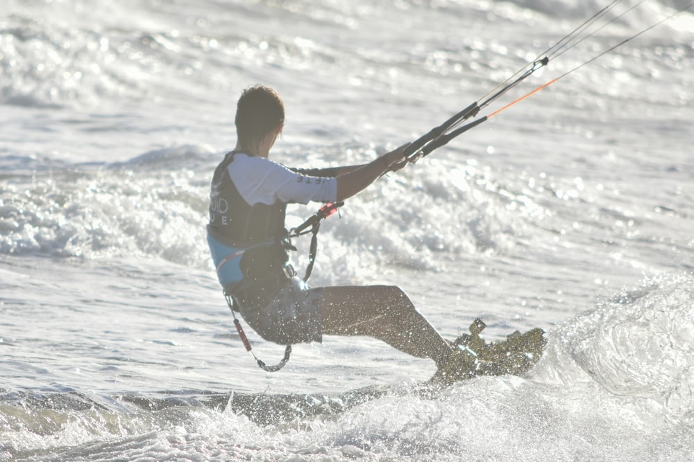 Mann in blau-gelbem Hemd und brauner Hose beim Surfen auf Meereswellen tagsüber