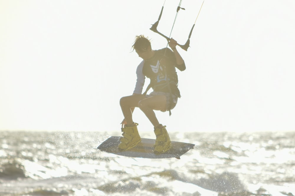 man in black shorts riding on brown wooden board on white snow during daytime