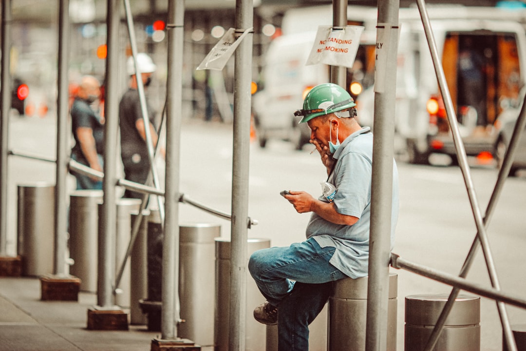 man in blue shirt and blue denim jeans wearing yellow helmet