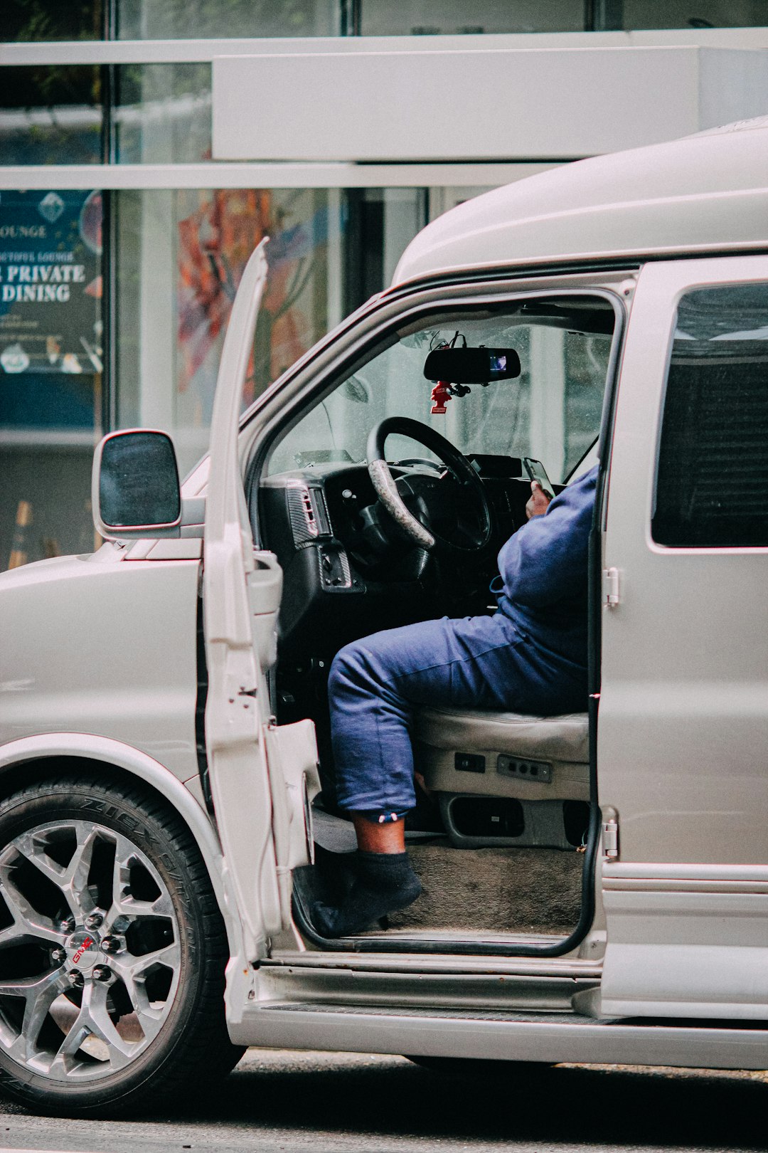 man in blue denim jeans sitting on white car