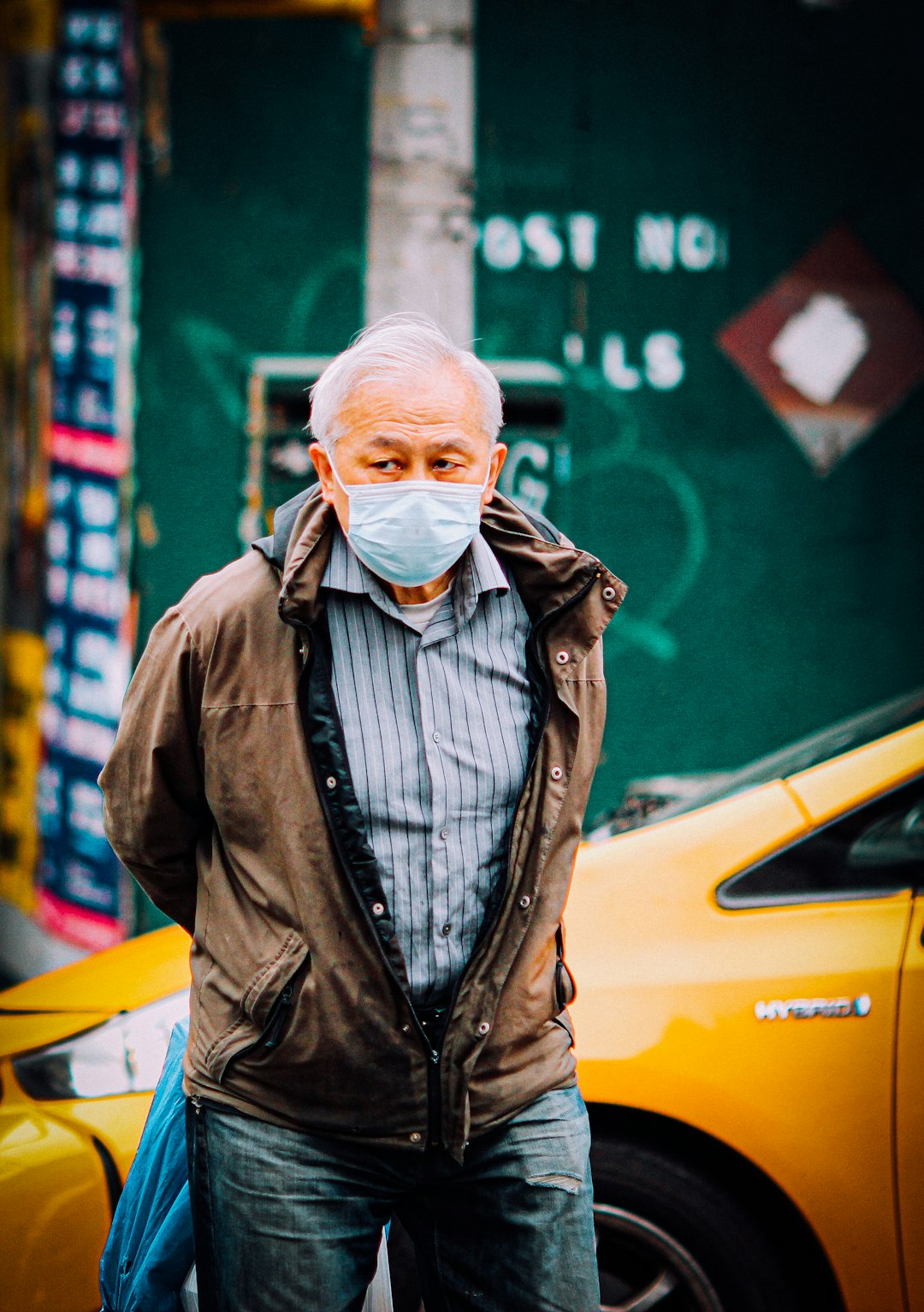 man in black leather jacket standing beside yellow car