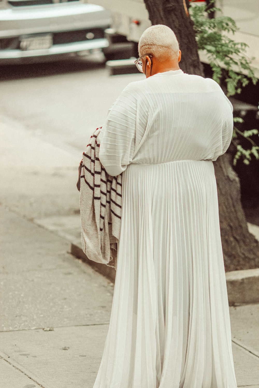 woman in white dress standing on road during daytime