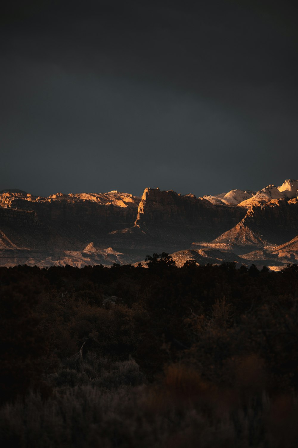 brown and white mountains under gray sky