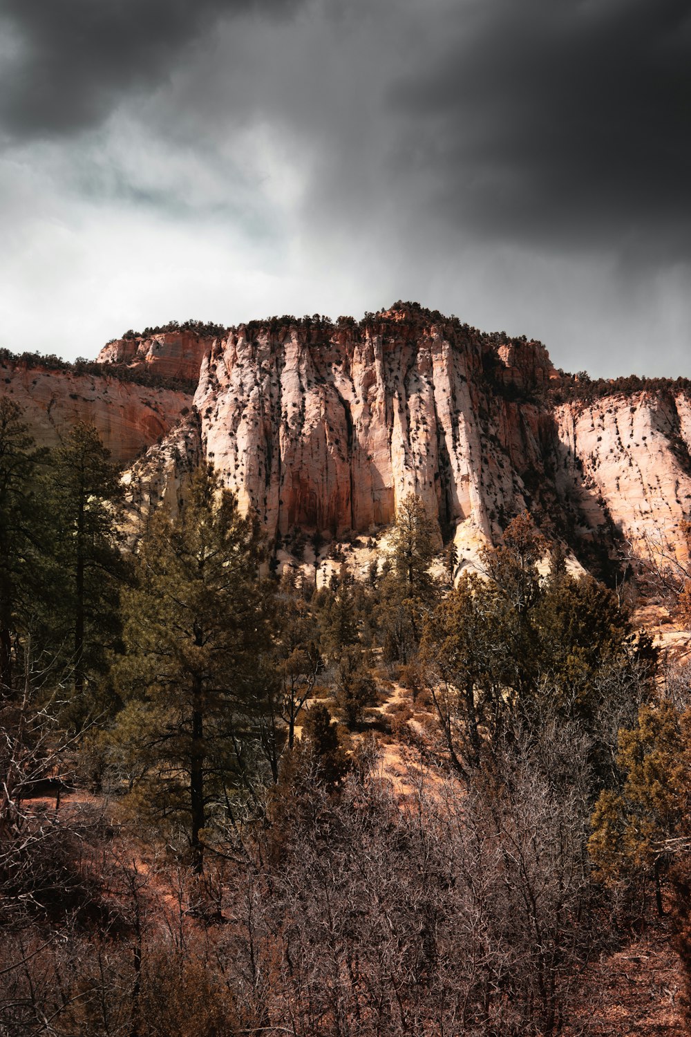 brown rocky mountain under gray cloudy sky