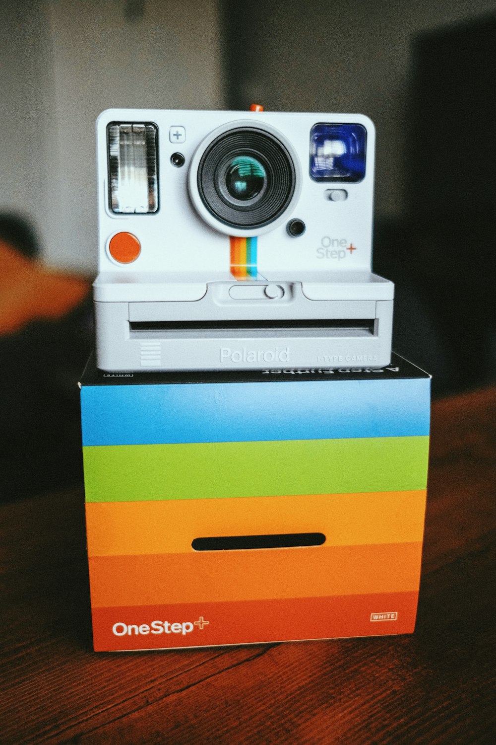 white and blue camera on yellow and blue striped box