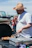 Smiling man grilling outdoors on a sunny day with a pellet grill