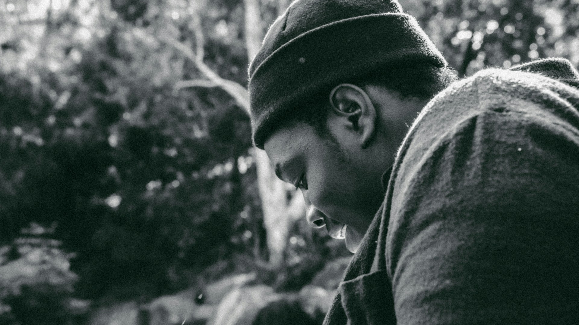 grayscale photo of man wearing hat and hoodie