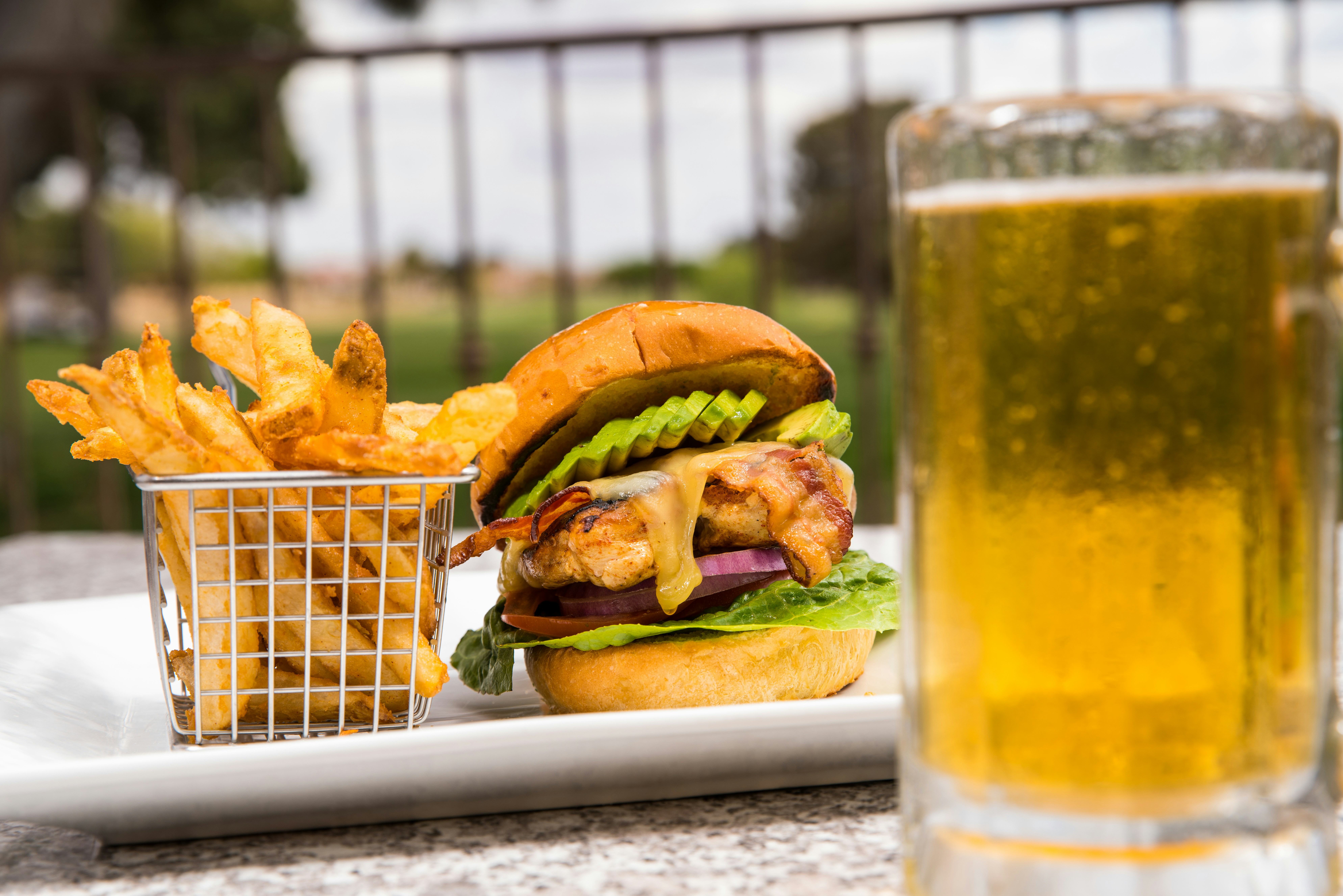 Burger and fries on a checked tray with a glass of beer