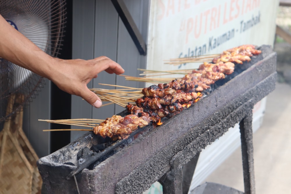 person holding a barbecue stick